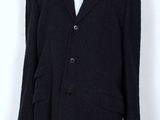 le mannequin porte un manteau noir et une chemise blanche
