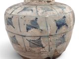 un vase bleu et blanc posé sur une surface blanche