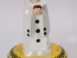 une petite figurine représentant un bonhomme de neige posée sur un bol jaune