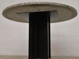 a round table with a black base and a white wall