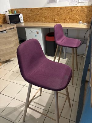 deux chaises violettes placées dans une cuisine, à côté d'un plan de travail