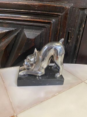 a statue of a cat that is laying down on a table