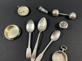 plusieurs cuillères en argent et d'autres couverts en argent posés sur un fond noir