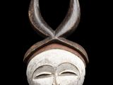 un gros plan d'un masque en bois orné de cornes