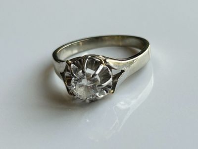 une image d'une bague en diamant sur une surface blanche