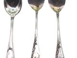 trois cuillères en argent et une cuillère avec un manche, sur fond blanc