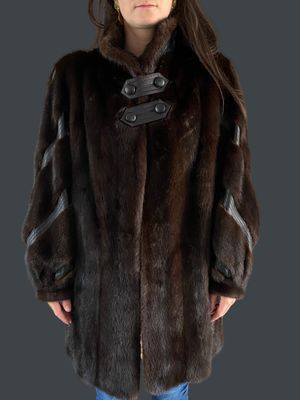 the woman is wearing a brown fur coat and blue jeans