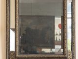 un miroir accroché au mur au-dessus de la cheminée dans un salon