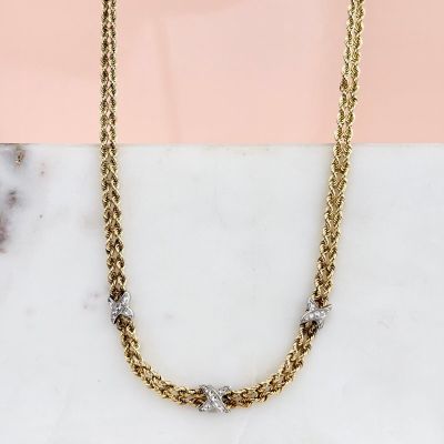 a photo of a gold chain necklace on a marble surface