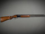 a shotgun with a wooden handle on a gray background