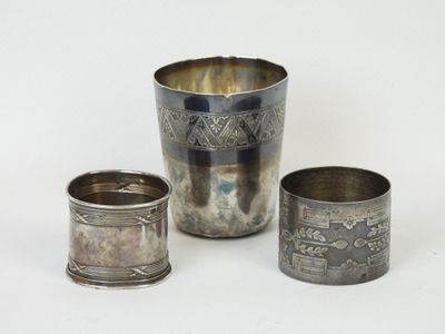 trois tasses en argent posées l'une à côté de l'autre sur une surface blanche