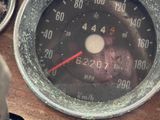 a close up of a speedometer on a wooden table
