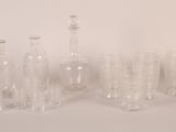 bottles and glasses are lined up in a row on a white surface