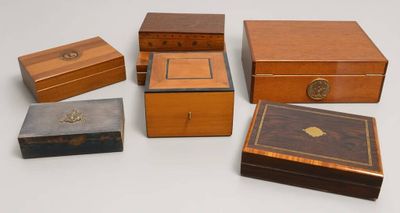 six petites boîtes en bois sont alignées sur une surface blanche