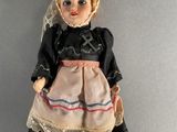a doll that is wearing a dress and a hat