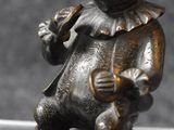a bronze statue of a teddy bear holding a guitar
