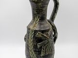 un vase noir et vert orné d'un oiseau