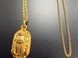 un collier en or orné d'un scarabée égyptien