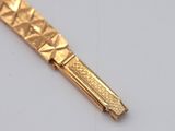a close up of a gold plated pen on a white surface
