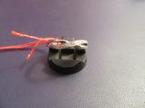 une bague en argent surmontée d'un cordon rouge