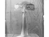 black and white photograph of a lamp on a table in front of a curtain