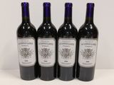 quatre bouteilles de vin sont alignées sur une table