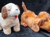 two stuffed animals sitting next to each other on a black background