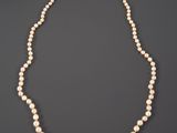a white pearl necklace with a gold clasp