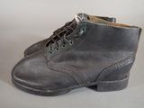 grey leather boots with laces on the side of them on a white surface