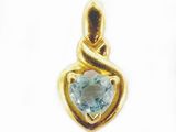 un gros plan sur un pendentif en forme de cœur orné d'une topaze bleue
