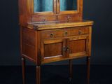 une vieille armoire en bois avec des portes vitrées et des tiroirs
