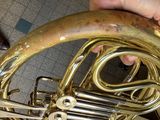a person holding a brass instrument in their hand