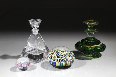 trois objets en verre de couleurs différentes posés sur une table