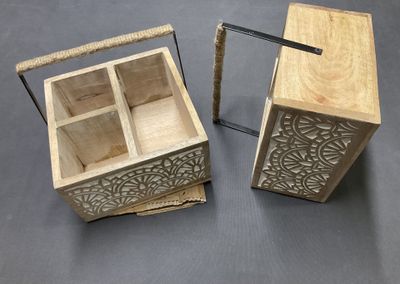 Deux boîtes en bois munies de poignées sont posées sur une table.