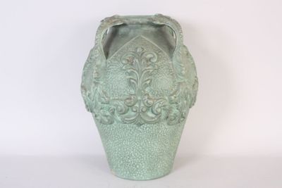 a green vase that is sitting on a white surface