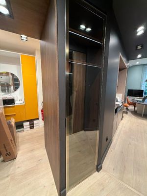 a glass door in the middle of a hallway leading to a living room