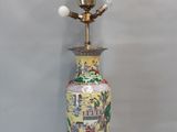 un vase posé sur une table, sur laquelle se trouve une lampe