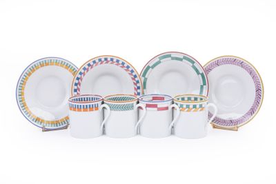 un ensemble d'assiettes et de tasses de différentes couleurs posées sur une surface blanche