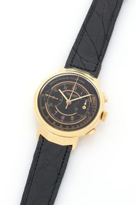 a close up of a watch on a white surface with a black strap