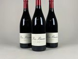 three bottles of red wine sitting on top of a table