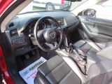 the interior of a red car with a steering wheel and dashboard