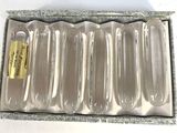 a box with six empty plastic spoons inside of it