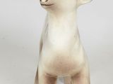 a small statue of a sheep standing on a white surface