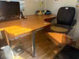 a desk with a computer and a chair in the room