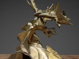 sculpture en bronze représentant une tête de dragon posée sur une table en marbre