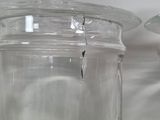 two glass jars that have a glass lid on top of them