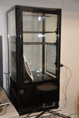 a glass case with a laptop in it on top of a stove