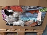 a cardboard box full of clothes sitting on a pallet