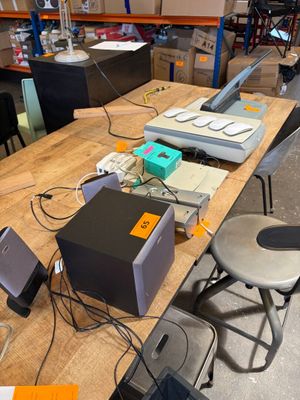 il y a beaucoup d'appareils électroniques sur la table dans la pièce