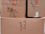 une pile de cartons posée sur une palette dans la rue